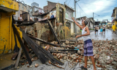Des habitants devant leurs maisons détruites par le passage de l'ouragan Melissa près de Santiago de Cuba, le 29 octobre 2025, à Cuba ( AFP / YAMIL LAGE )